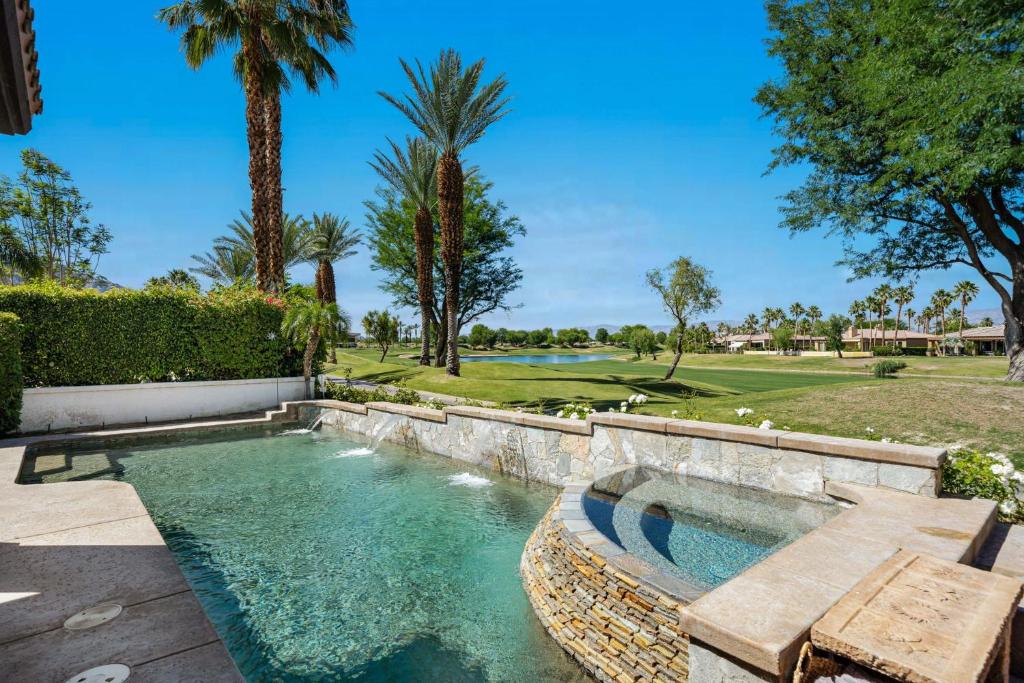 a pool in a yard with a bench and trees at PGA West Golf Course Pool & Spa Home in La Quinta