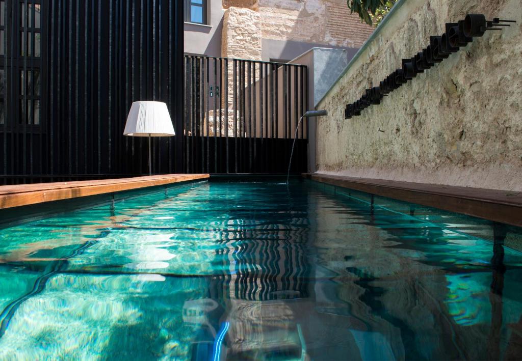 a swimming pool with a lamp next to a building at Caro Hotel in Valencia