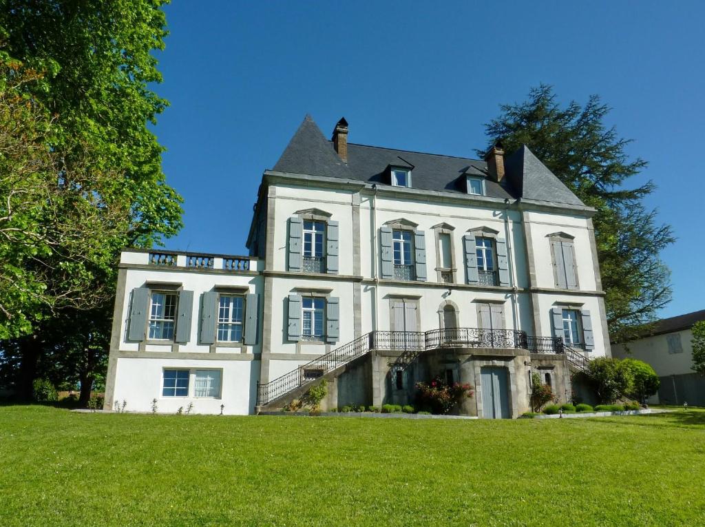 Chambres d'Hôtes Aire Berria في Irissarry: منزل أبيض كبير على عشب أخضر
