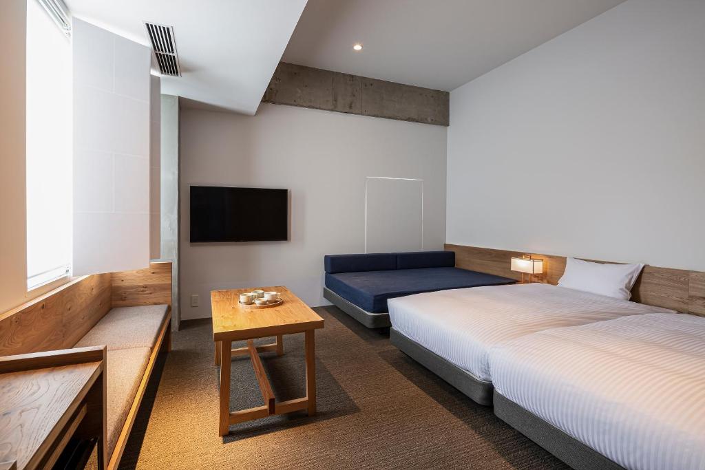 Postel nebo postele na pokoji v ubytování TSUGU Kyoto Sanjo by THE SHARE HOTELS