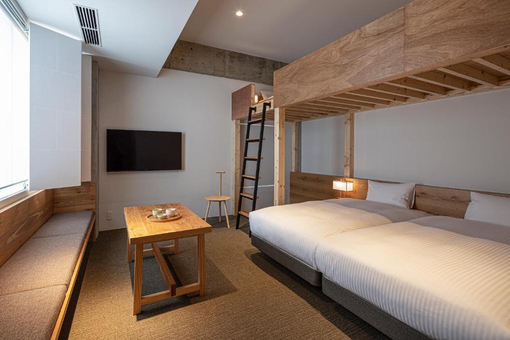 Postel nebo postele na pokoji v ubytování TSUGU Kyoto Sanjo by THE SHARE HOTELS