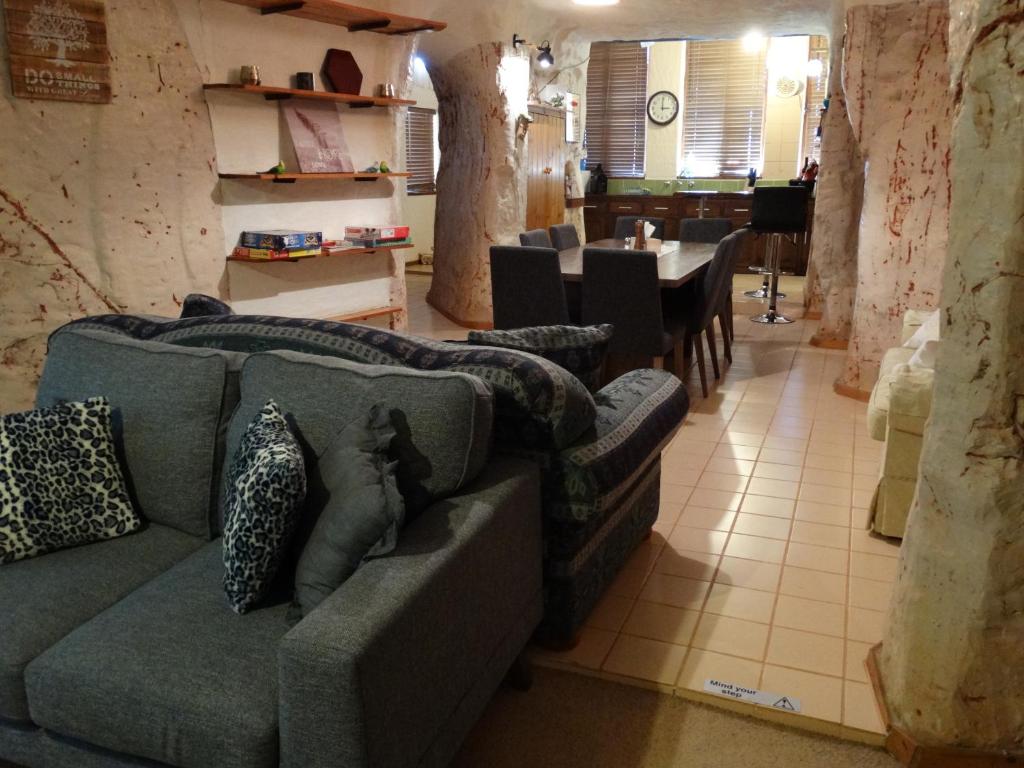 
a living room with a couch and a table at Dinky Di's Dugout in Coober Pedy
