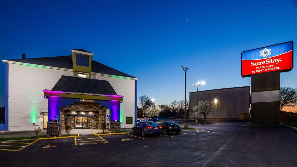 a store front with purple lighting in a parking lot at SureStay Plus Hotel by Best Western Blue Springs in Blue Springs