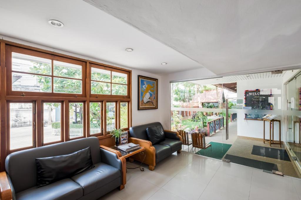 A glass-fronted lobby lounge offers black sofas beside the reception area.