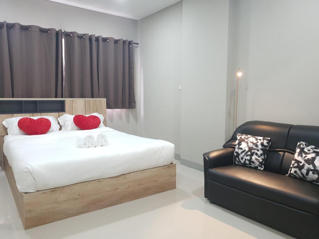 a bedroom with a bed and a leather chair at iResidence hotel in Ban Khlong Nung