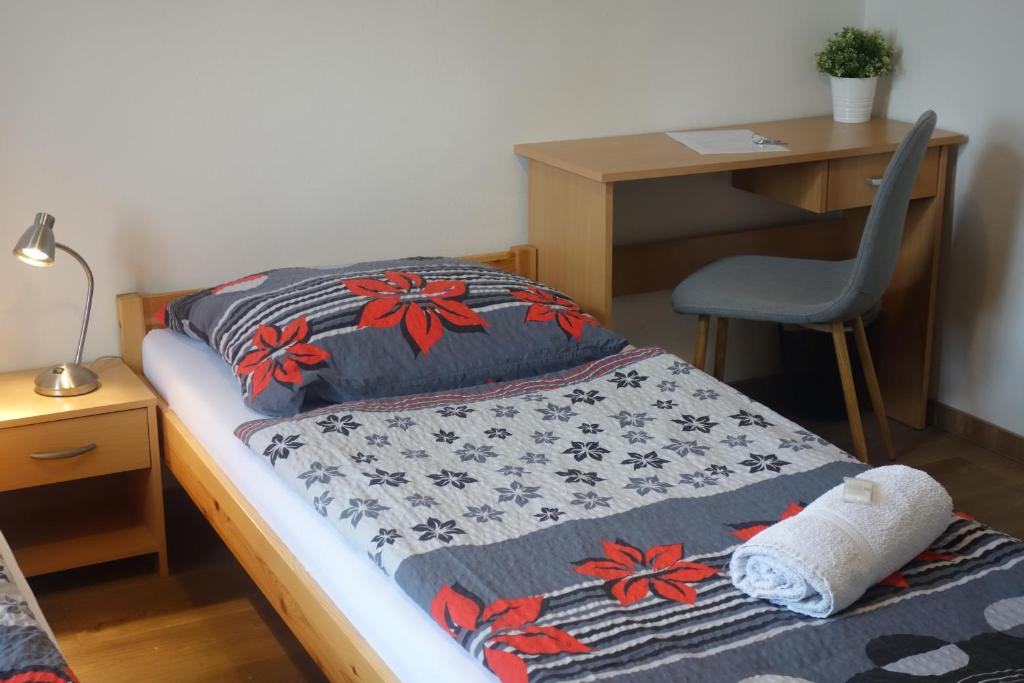 a bedroom with a bed with a desk and a chair at Hostel Bed - Breakfast Brno in Brno