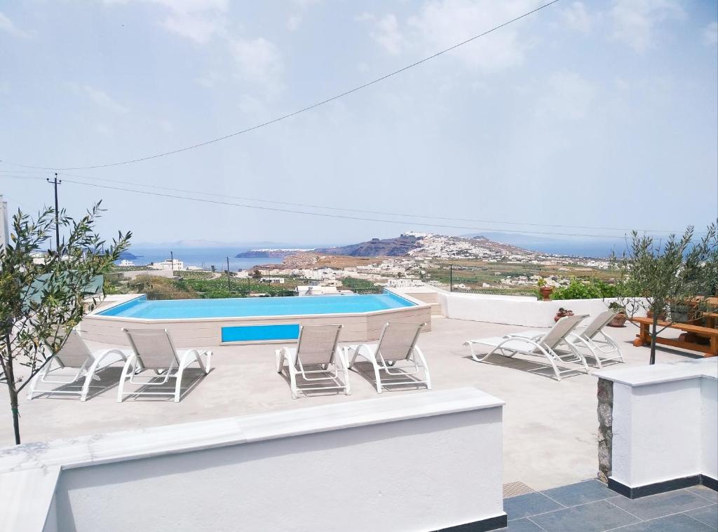 patio con sedie e piscina di Aroma Cavas a Pyrgos