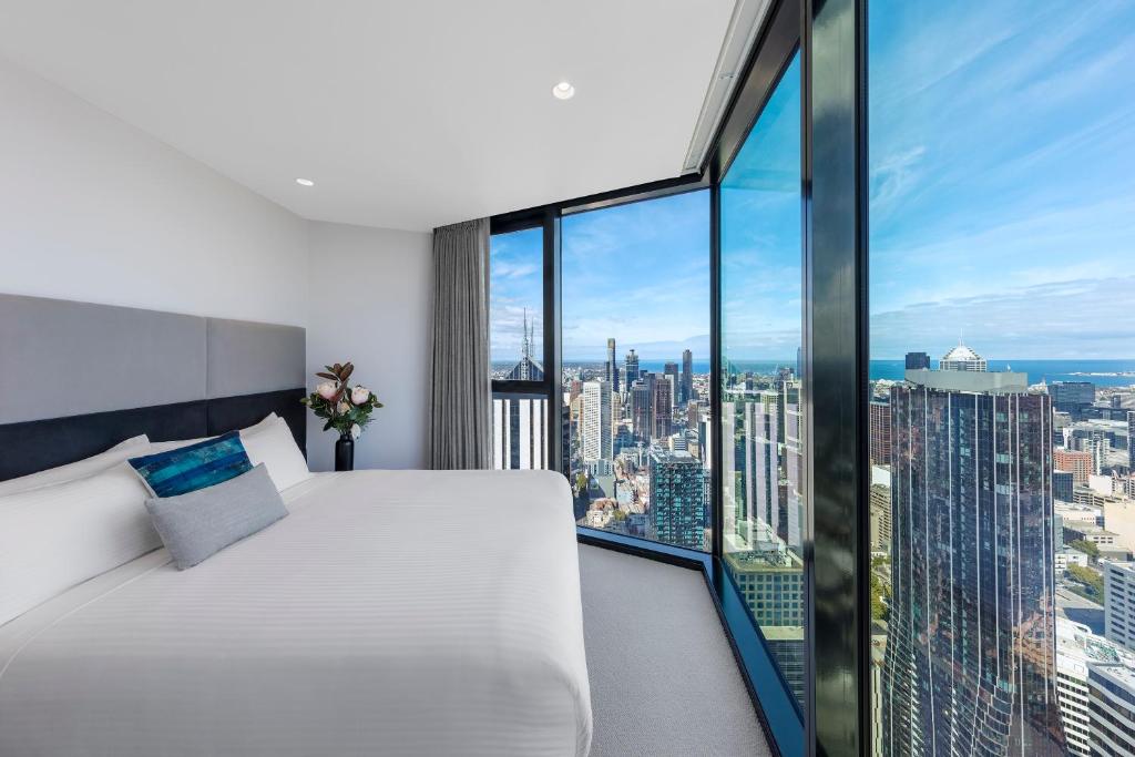 una camera da letto con un letto bianco e una grande finestra di Imagine Lighthouse a Melbourne