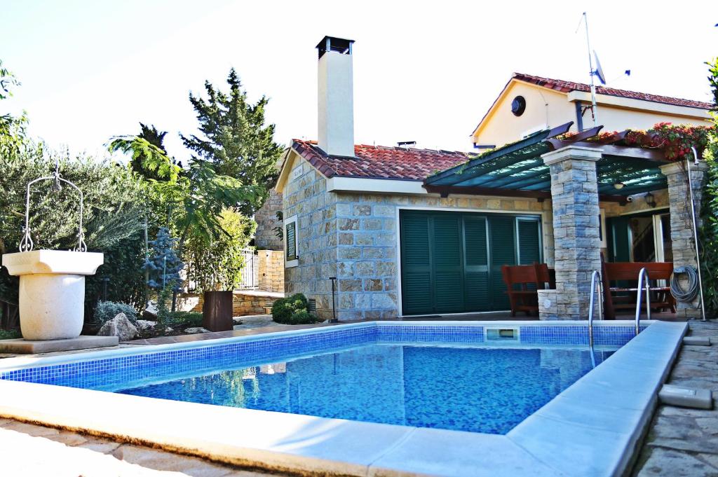 a swimming pool in front of a house at Villa Anja in Pražnice