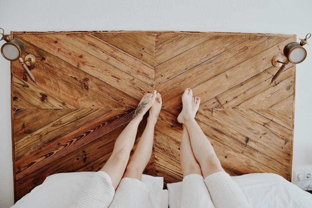 a woman laying on a bed with her feet on a wall at Centro SPA Atostogų namai in Birštonas