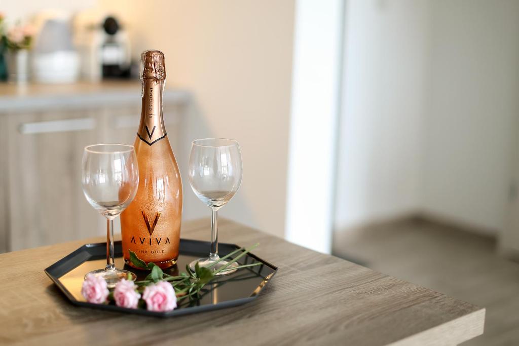 a bottle of champagne and two glasses on a table at Apartament Grey in Mielno