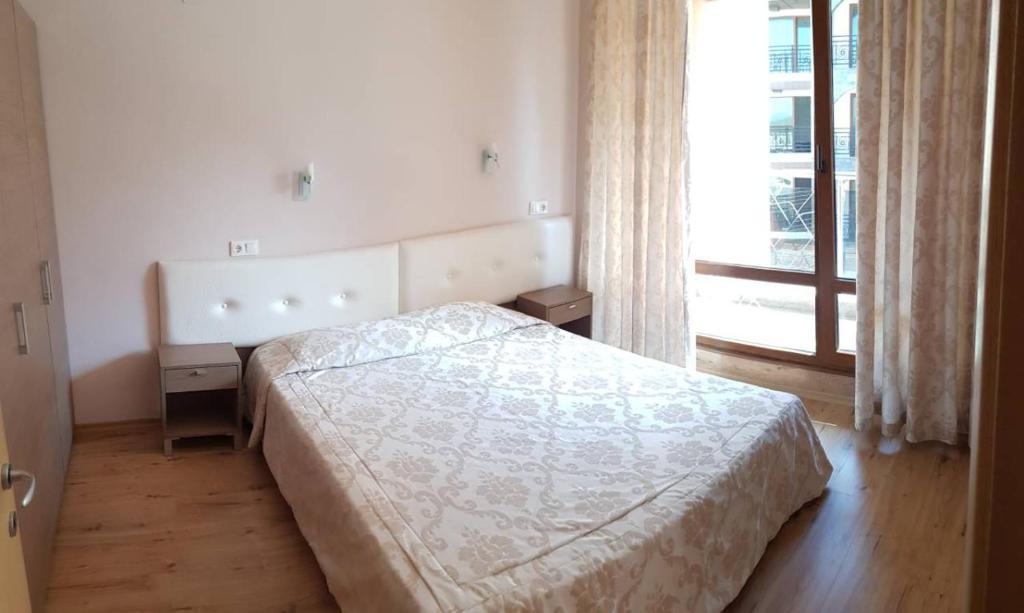 een slaapkamer met een bed en een raam bij Apartment By The Sea in Pomorie