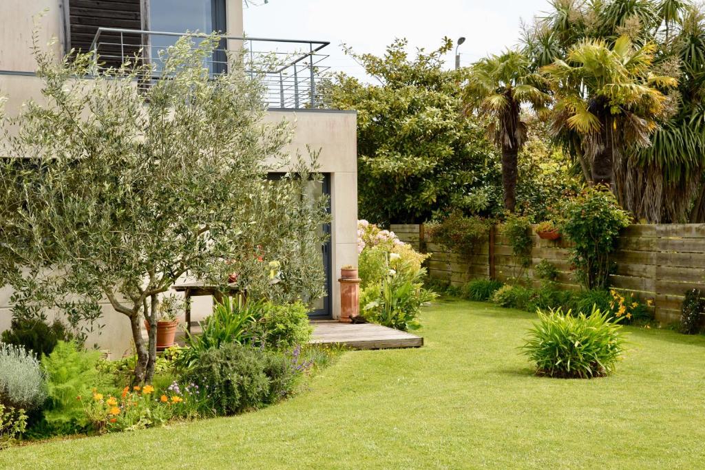 - un jardin avec un banc en bois dans la cour dans l'établissement Studio Les Terrasses de Kerangall, à Brest