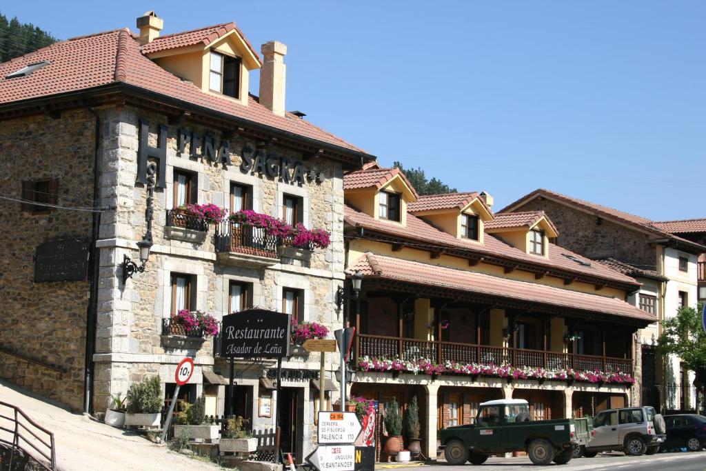 un bâtiment avec des fleurs sur les balcons dans une rue dans l'établissement Hosteria Peña Sagra, à Ojedo