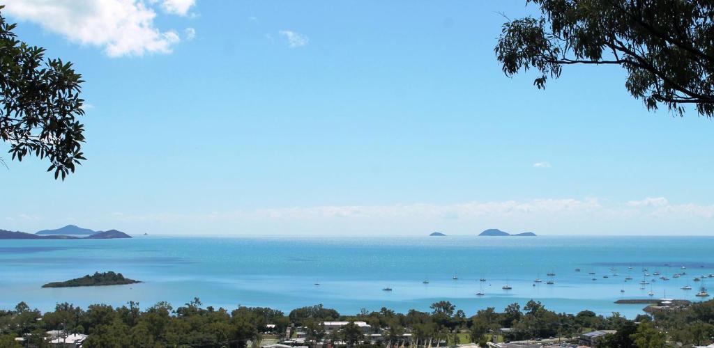 a large body of water with mountains at Yachtsmans Paradise, Whitsundays in Airlie Beach