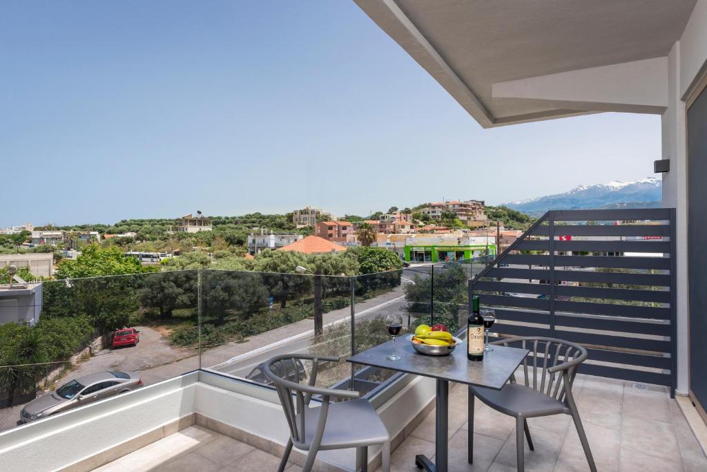 a balcony with a table and chairs and a view at Aequor Luxury Rooms & Apartments in Kato Daratso