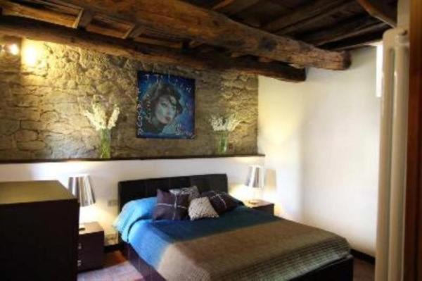 Un dormitorio con una cama azul y una pared de piedra en Crocino (appartamento al piano superiore), en Loro Ciuffenna