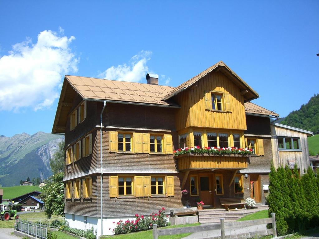 una grande casa in legno con dei fiori di fronte di Urlaub bei Moses a Schoppernau
