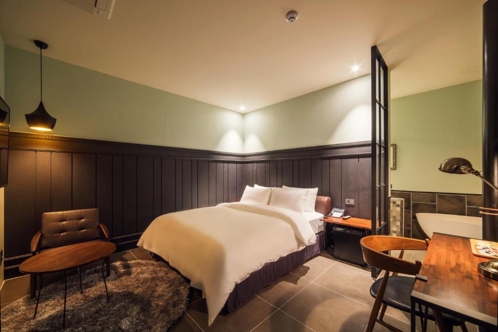 a bedroom with a bed and a table and chairs at Hotel March in Daejeon