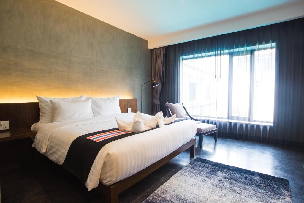 Postel nebo postele na pokoji v ubytování NAI YA Hotel -SHA Extra Plus