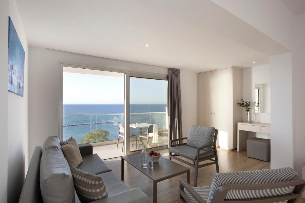 a living room with a couch and a view of the ocean at Harmony Bay Hotel in Limassol