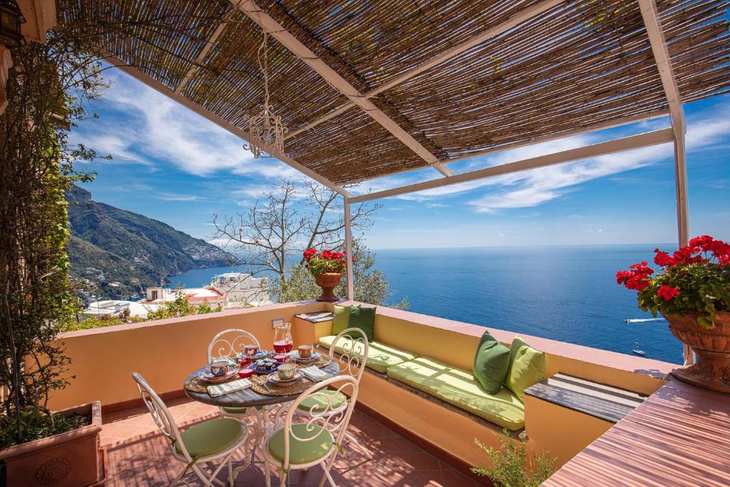 balkon ze stołem i krzesłami oraz oceanem w obiekcie Casa Marina w mieście Positano