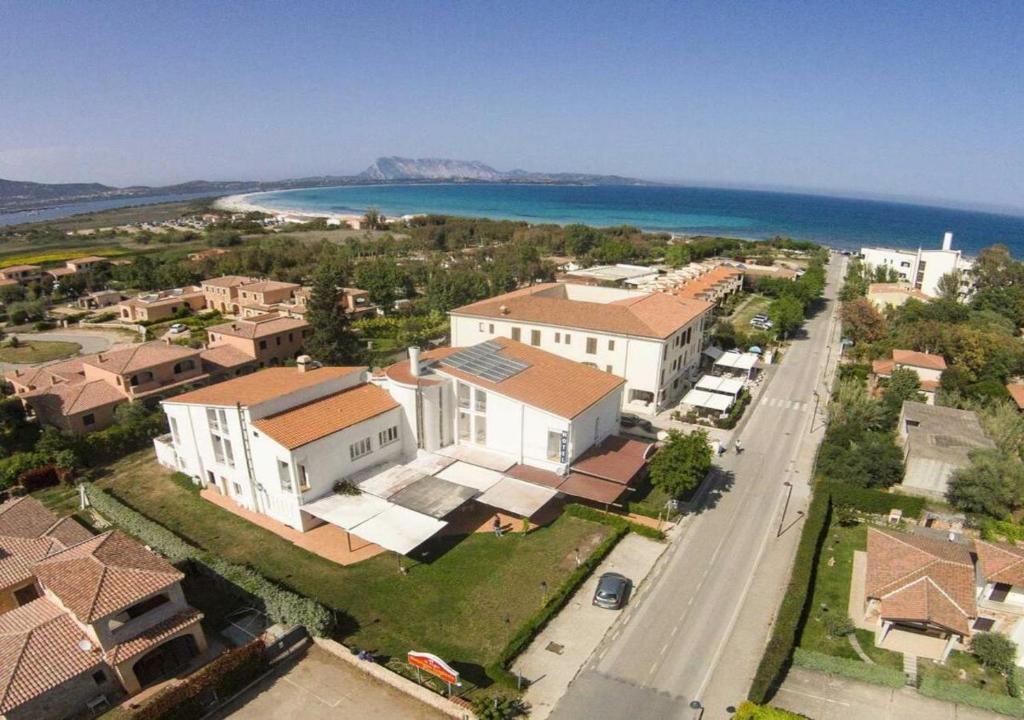 una vista aerea di una piccola città con case e l'oceano di Hotel Al Faro a San Teodoro