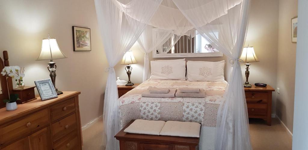 a bedroom with a bed with a canopy at Papillon Guest Suite in Simonʼs Town