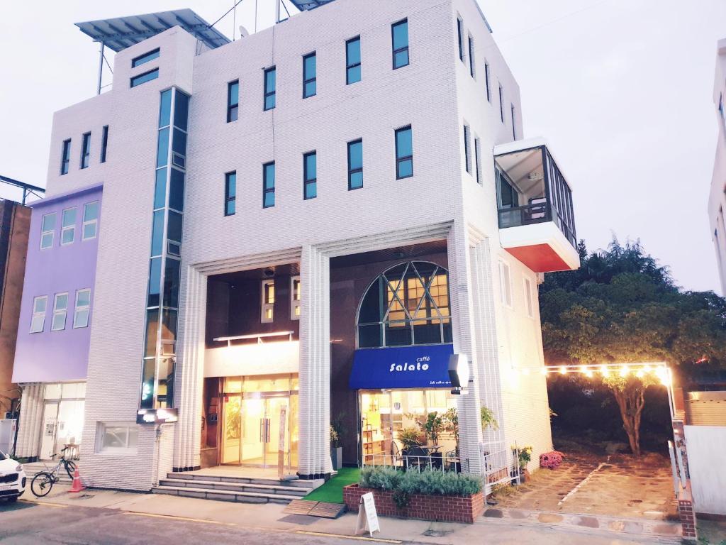 a white building with a market sign on it at Picasso Guesthouse in Mokpo