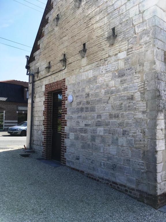 a brick building with a door in the side of it at Gite de sejour la grange de Théophile in Anzin-Saint-Aubin