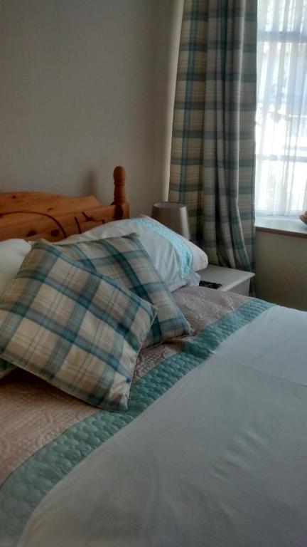 a bedroom with a bed with a pillow and a window at Lewinsdale Lodge in Weston-super-Mare