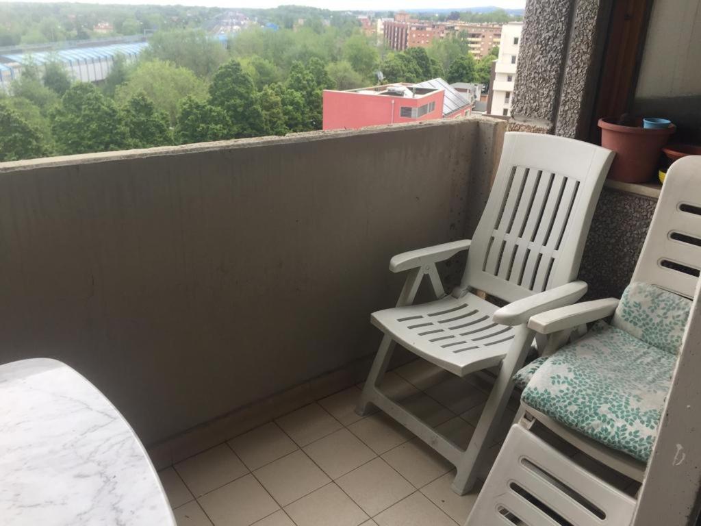 balkon z 2 białymi krzesłami i oknem w obiekcie Stanza in appartamento privato Zona San vitale w Bolonii