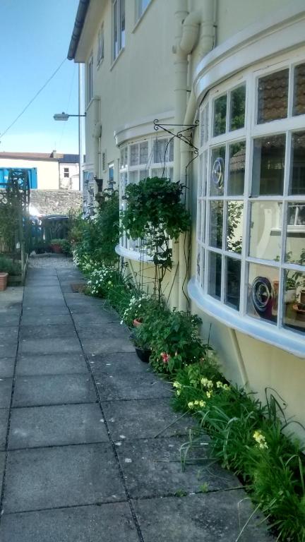 a sidewalk in front of a building with plants at Lewinsdale Lodge in Weston-super-Mare
