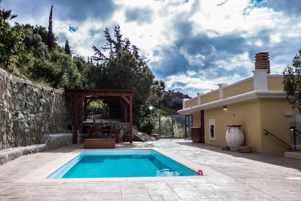 a swimming pool in a yard next to a house at Olenia Residence in Agia Pelagia