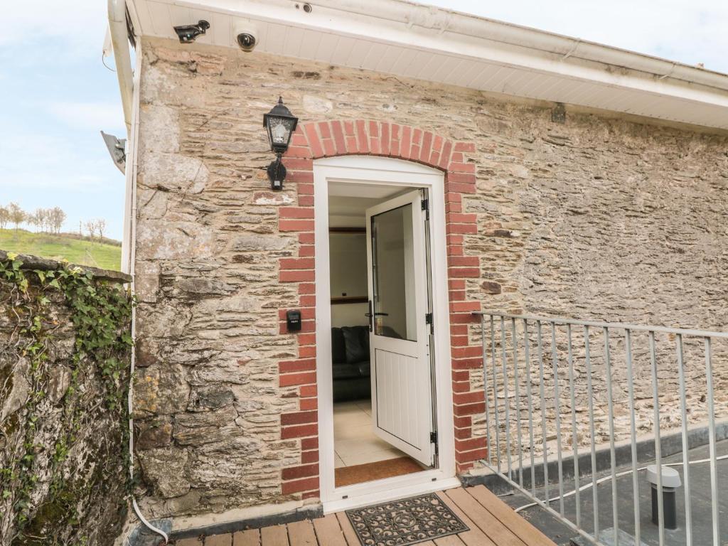 a brick house with a white door on a balcony at Lower Norton Apartment in Dartmouth