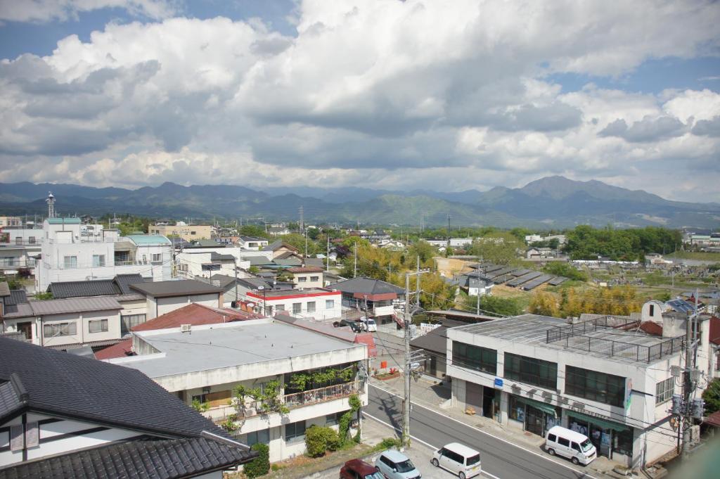 una ciudad con edificios y montañas en el fondo en Guest House Japan Heart, en Hokuto