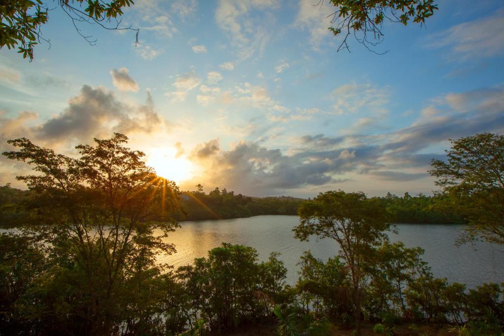 a view of a lake with the sun setting at Tri by Amaya in Ahangama