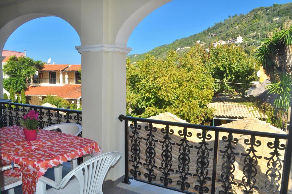 uma mesa e cadeiras numa varanda com vista em Holiday Apartments yannis on Agios Gordios beach in Corfu em Agios Gordios