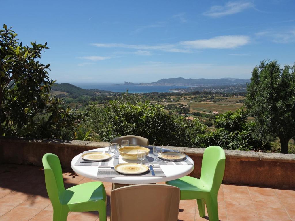 a table with plates of food and chairs on a balcony at Holiday Home Les Vignes by Interhome in Saint-Côme