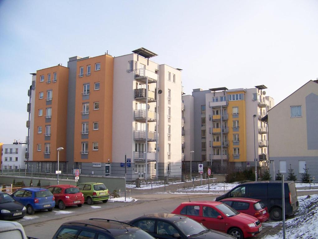 a parking lot with cars parked in front of buildings at Przytulne mieszkanie in Gdańsk