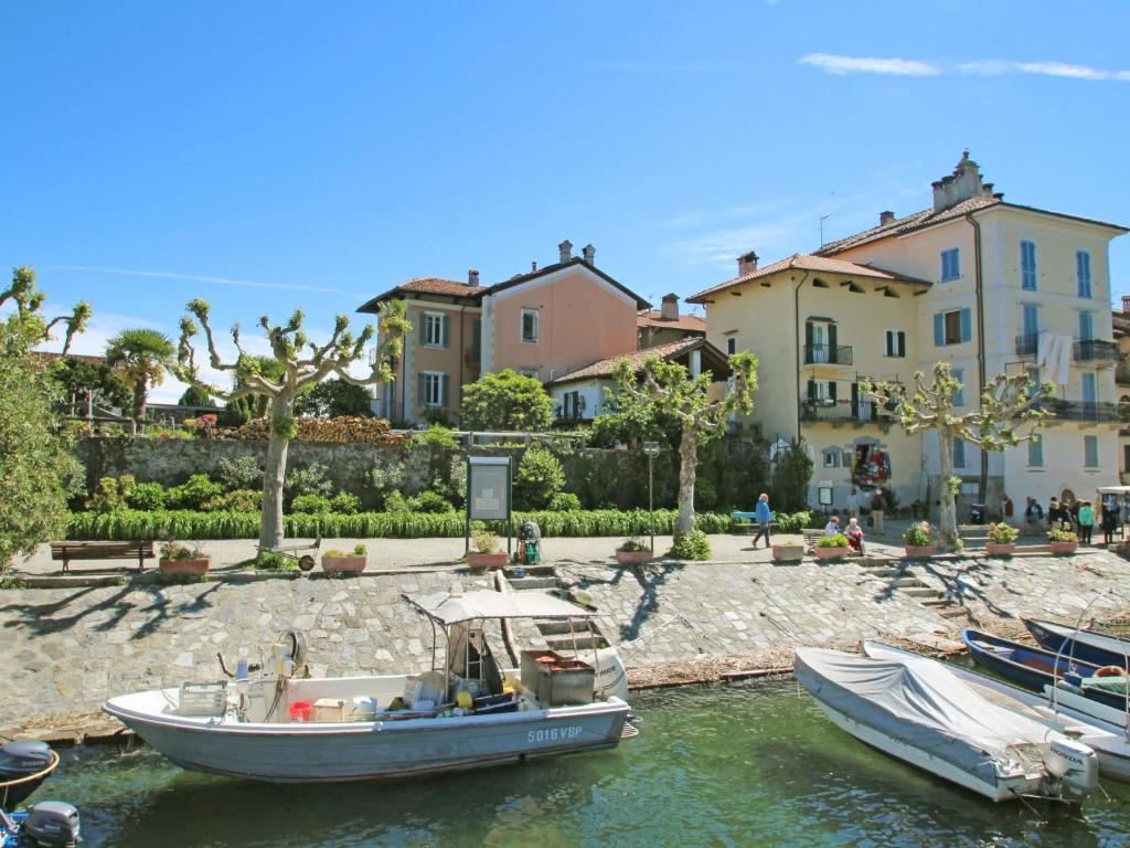 deux bateaux dans l'eau devant les maisons dans l'établissement Apartment La Silente by Interhome, à Stresa