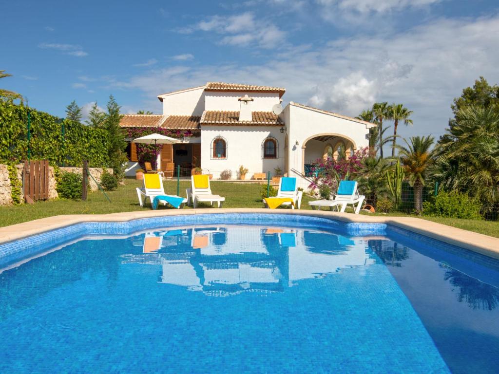 a villa with a swimming pool in front of a house at Holiday Home Adsubia by Interhome in Jávea