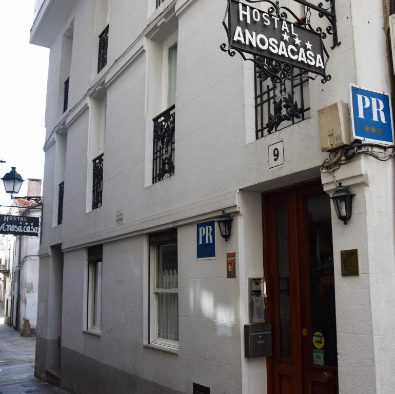 un edificio con un cartel en el costado en Hostal Anosa Casa, en Santiago de Compostela