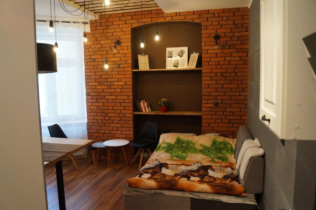 羅茲的住宿－Apartament Czekoladowy，一间设有砖墙和一张桌子的客厅
