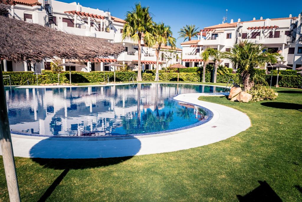 a swimming pool in front of a building at Apartamentos Coto de San José in Chiclana de la Frontera