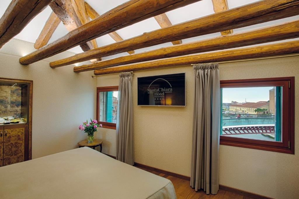 a bedroom with a bed and a large window at Hotel Santa Chiara in Venice