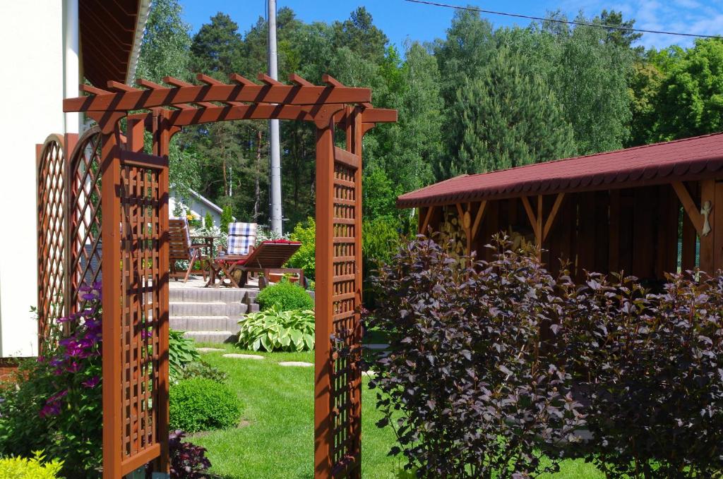 a wooden pergola in a garden next to a house at U Iwony in Sztutowo