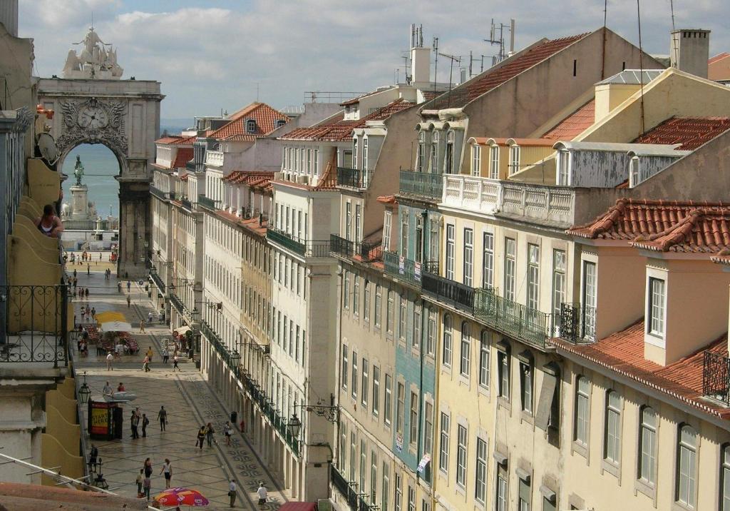 eine Stadtstraße mit Gebäuden und einem Uhrturm in der Unterkunft Home in Lisbon Duplex in Lissabon