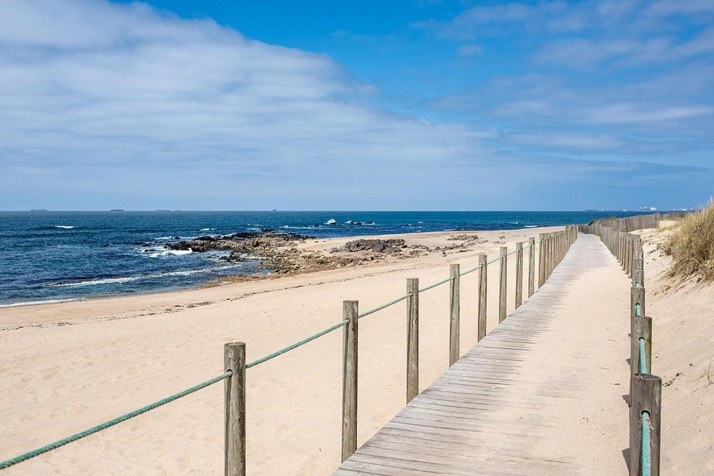 un paseo marítimo de madera en una playa cerca del océano en Madalena Beach Apartment by MP, en Madalena