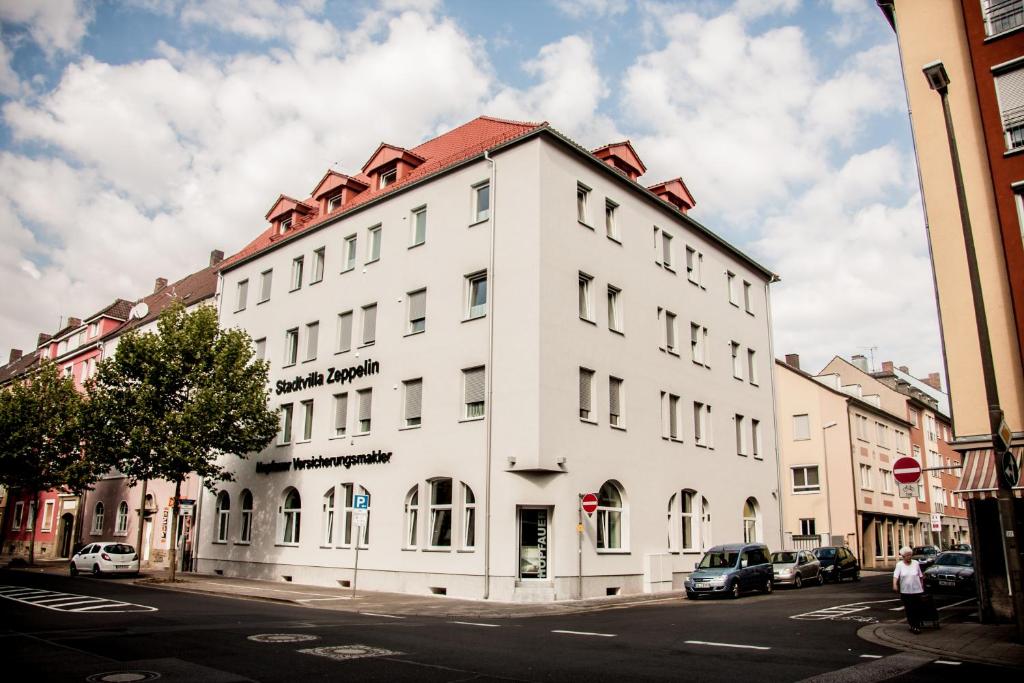 a white building with a red roof on a street at Aparthotel - Stadtvilla Premium in Schweinfurt